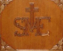 Sigle du Séminaire sur un prie-dieu à la Salle des prêtres