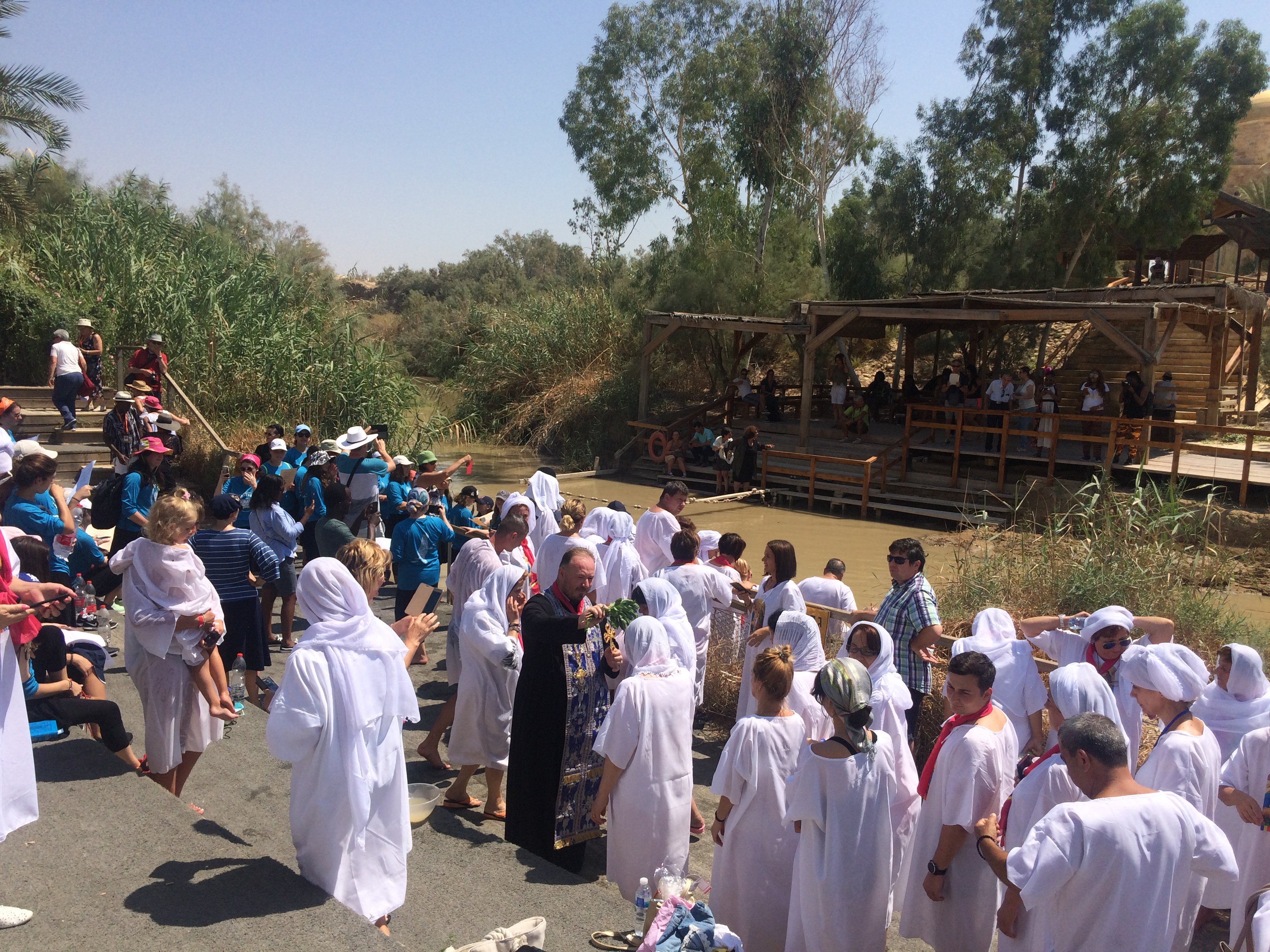 Pèlerins renouvelant leur baptême au Jourdain à l'endroit présumé où prêchait Jean-Baptiste (Crédits photo: H. Giguère)